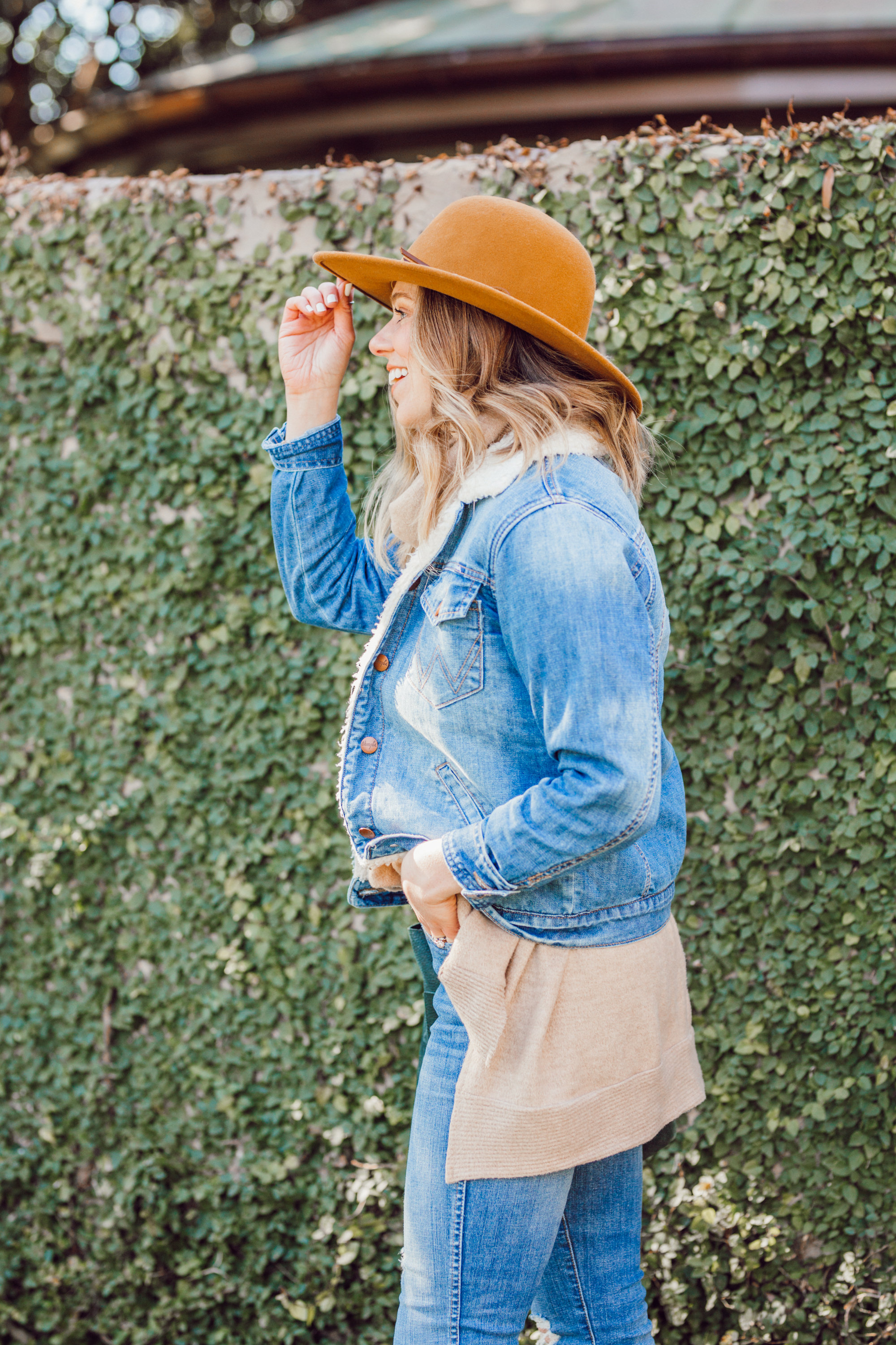 Favorite Winter Boots featured by top US fashion blogger Laura Leigh of Louella Reese; Image of woman sherpa denim jacket, Madewell high-waist skinny jeans, Madewell suede transport tote, Bronze wool hat, Ariat Two24 wilder boots.