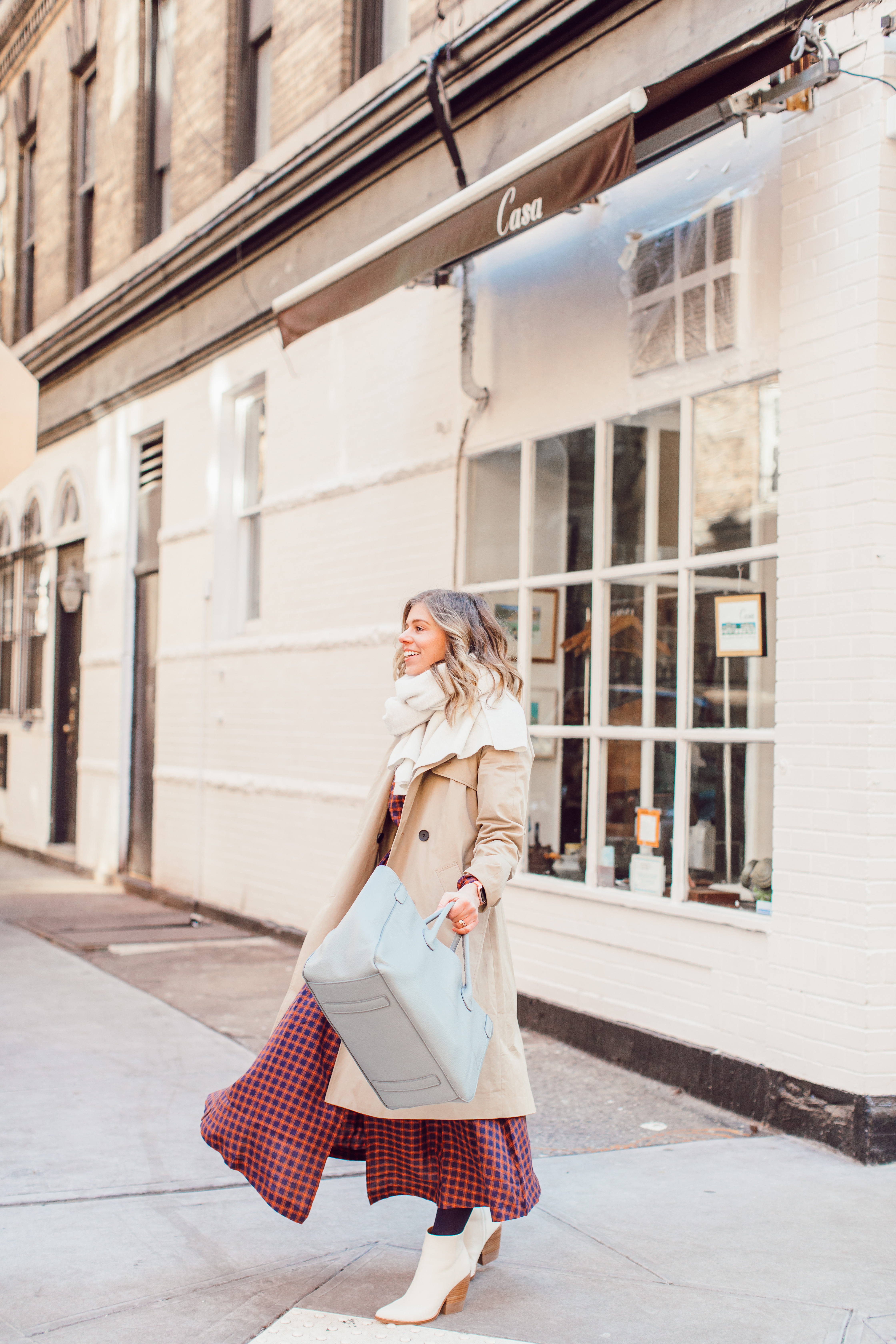 The Perfect Trench Coat styled by top US fashion blogger Laura Leigh of Louella Reese; Image of woman wearing Everyone Drape Trench Coat, & Other Stories Plaid Midi Dress, Marc Fisher LTD Belle Booties, Zac Beck Bags Medium Classic Tote | How to Style a Trench Coat for Winter